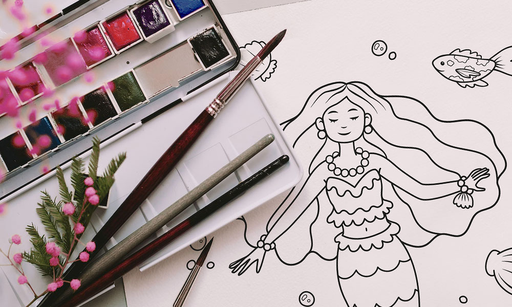 Mermaid coloring page with watercolors on the side.