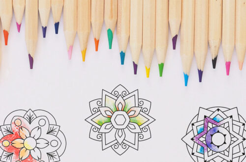 There are coloring pencils in a row at the top of the picture. Below them are three simple, half-colored mandalas.